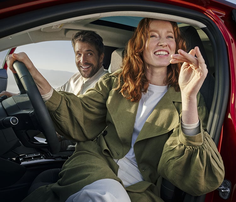 Man and woman aboard Citroën Ë-C4 electric, open door